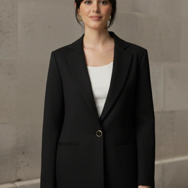 Woman wearing a black blazer over a white shirt with a neutral background