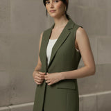 Three-quarter angle of a woman wearing an unbuttoned olive green longline vest over a white top, highlighting the garment's elegant drape and tailored fit.