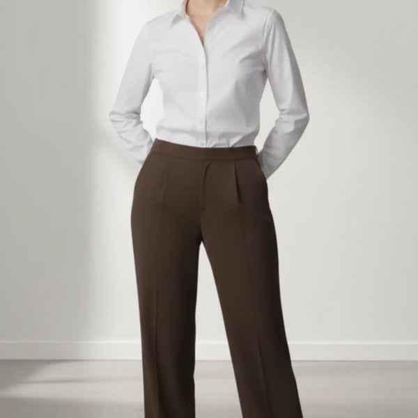 Woman wearing a white shirt and mocha trouser on a plain background