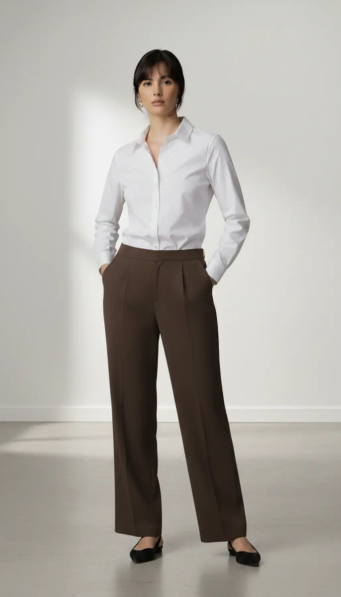 Person wearing a white shirt and mocha trouser on a plain background