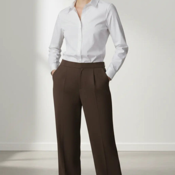 Person wearing a white shirt and mocha trouser on a plain background