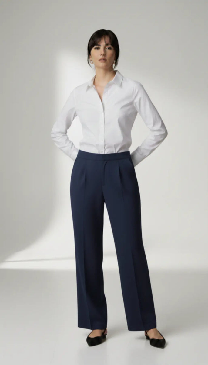 Person wearing a white shirt and navy pants on a white background
