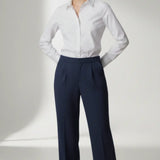 Person wearing a white shirt and navy pants on a white background