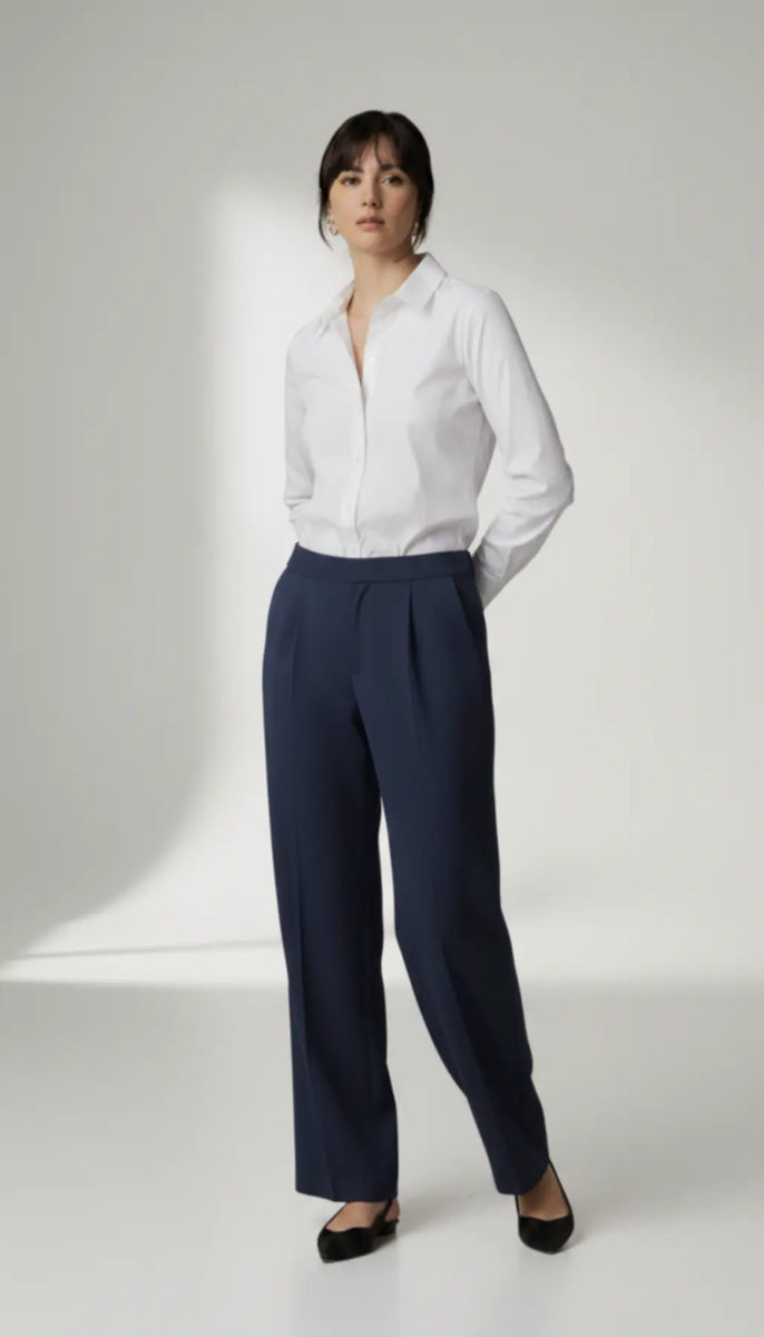 Person wearing a white shirt and navy pants on a white background