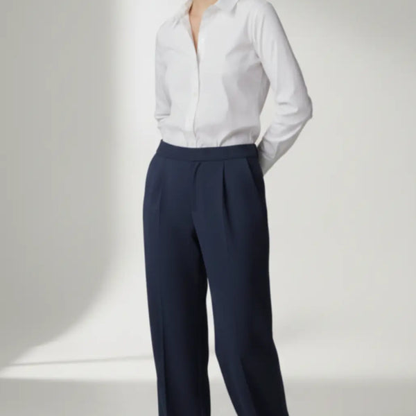 Person wearing a white shirt and navy pants on a white background