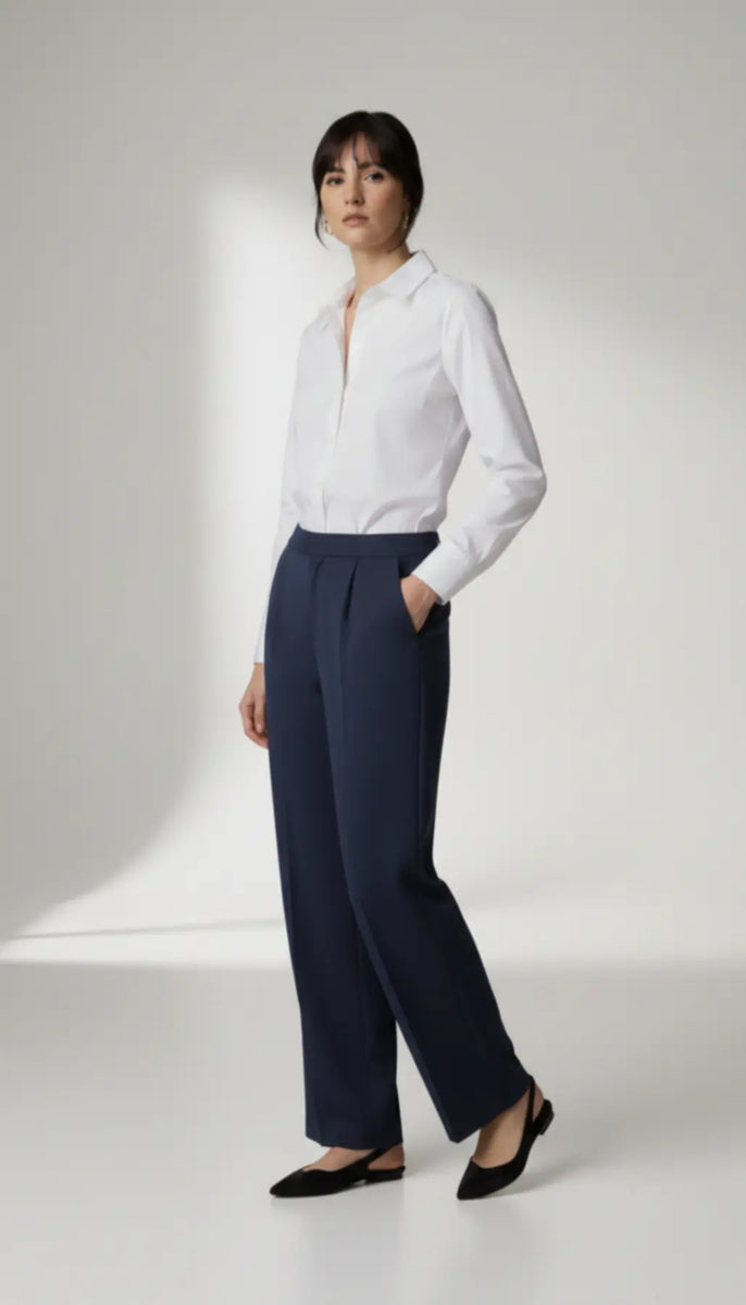 Person wearing a white blouse and navy pants on a white background