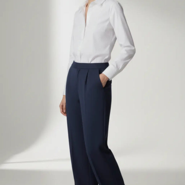 Person wearing a white blouse and navy pants on a white background