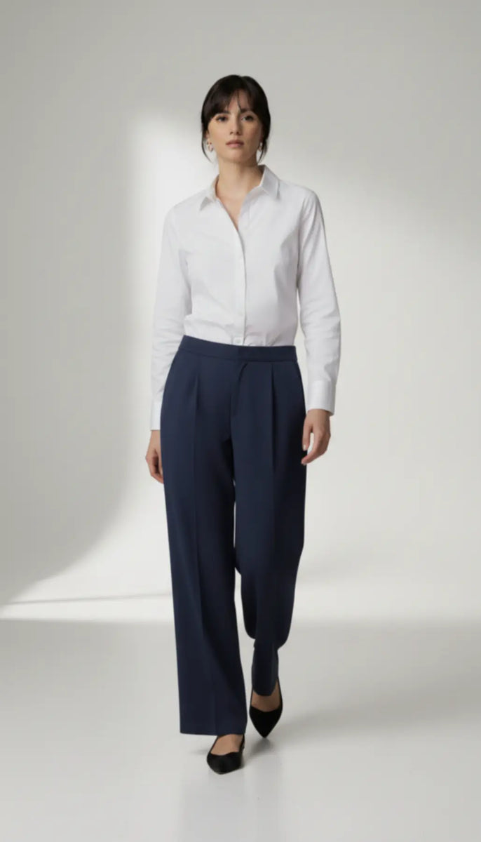 Person wearing a white shirt and navy pants on a white background