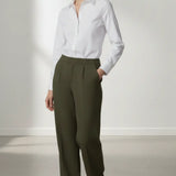 Person wearing a white shirt and olive pants against a white background