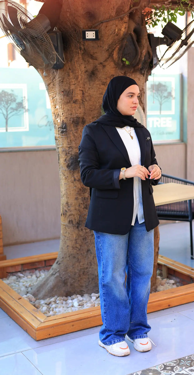 “ZAYTA black women’s blazer on model with white shirt and blue jeans, standing near a tree”
