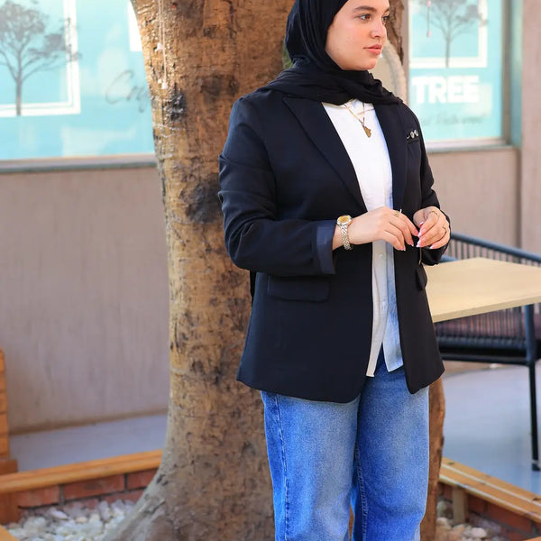 “ZAYTA black women’s blazer on model with white shirt and blue jeans, standing near a tree”
