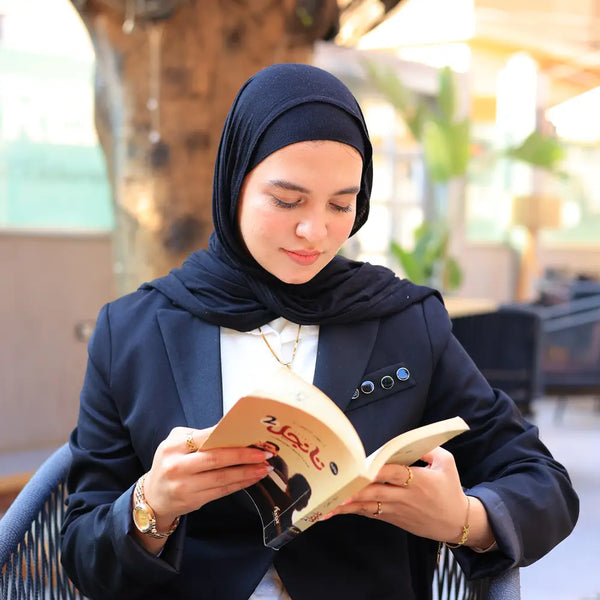 “ZAYTA black women’s blazer on model reading a book outdoors at a table with blurred background”
