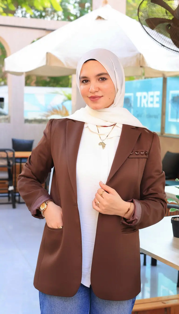 ZAYTA brown tailored blazer on model wearing hijab, showing fabric and inner lining, outdoor setting
