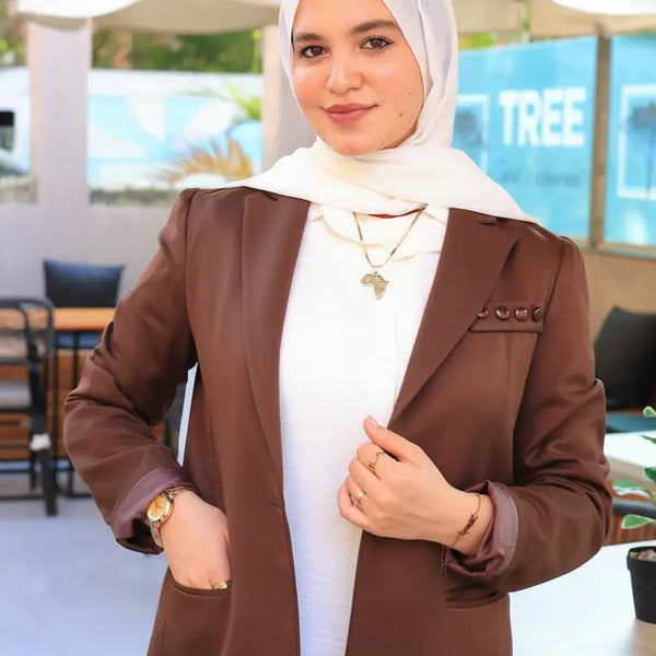 ZAYTA brown tailored blazer on model wearing hijab, showing fabric and inner lining, outdoor setting
