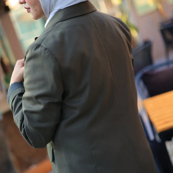 ZAYTA green tailored coat on model wearing a headscarf in an outdoor setting, showcasing clean fit and premium fabric details