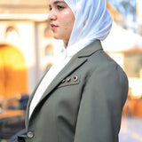 ZAYTA Olive tailored blazer on model wearing white hijab, with a softly blurred background, showcasing fit and premium fabric details
