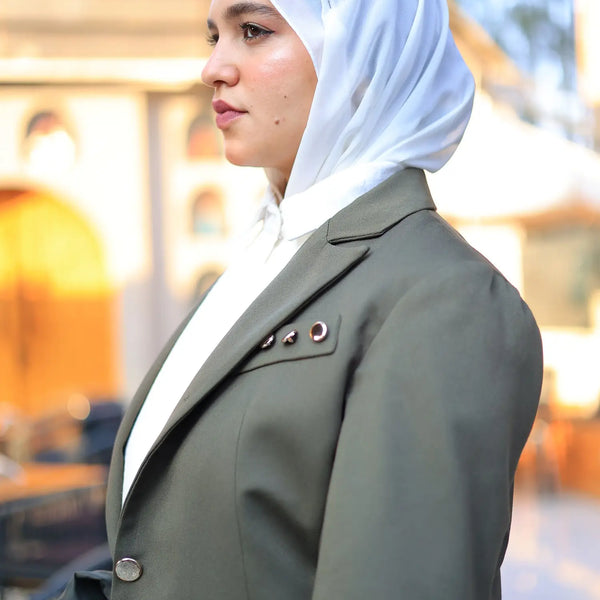 ZAYTA Olive tailored blazer on model wearing white hijab, with a softly blurred background, showcasing fit and premium fabric details