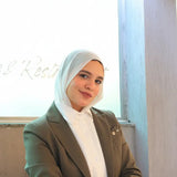 ZAYTA formal outfit with olive blazer on model wearing a hijab, sitting at a desk, highlighting tailored fit and professional style