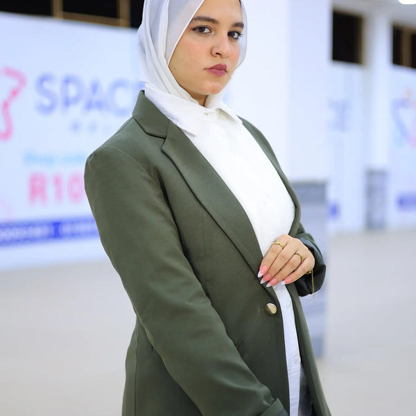 ZAYTA olive tailored blazer on model wearing white hijab, showing fabric and inner lining, indoor setting
