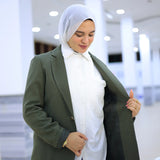 ZAYTA Olive tailored blazer on model over white shirt and blue jeans, showing fabric and inner lining, indoor setting
