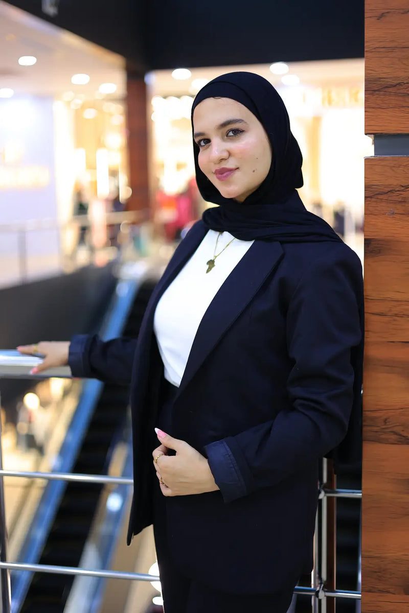“ZAYTA off white women’s blazer on model wearing black hijab and dark outfit, indoor setting with blurred background”
