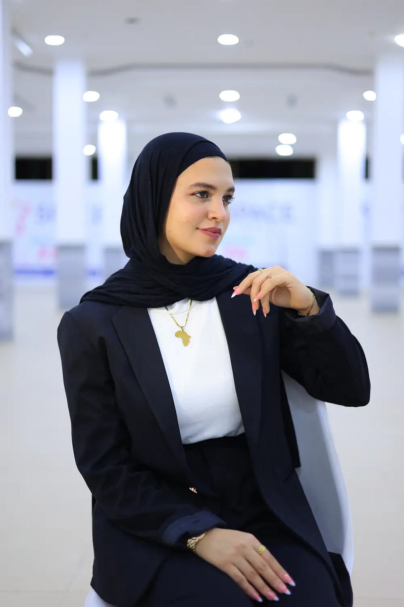 “ZAYTA off white women’s blazer on model wearing black hijab, indoor setting”
