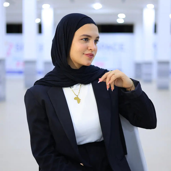 “ZAYTA off white women’s blazer on model wearing black hijab, indoor setting”
