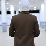 ZAYTA brown tailored blazer on model wearing white hijab, showing fabric and inner lining, indoor setting
