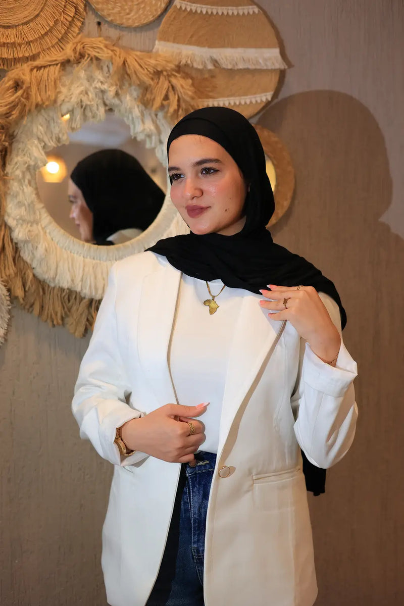 “ZAYTA off white women’s blazer on model wearing black hijab, tailored fit, in front of decorative wall mirrors”