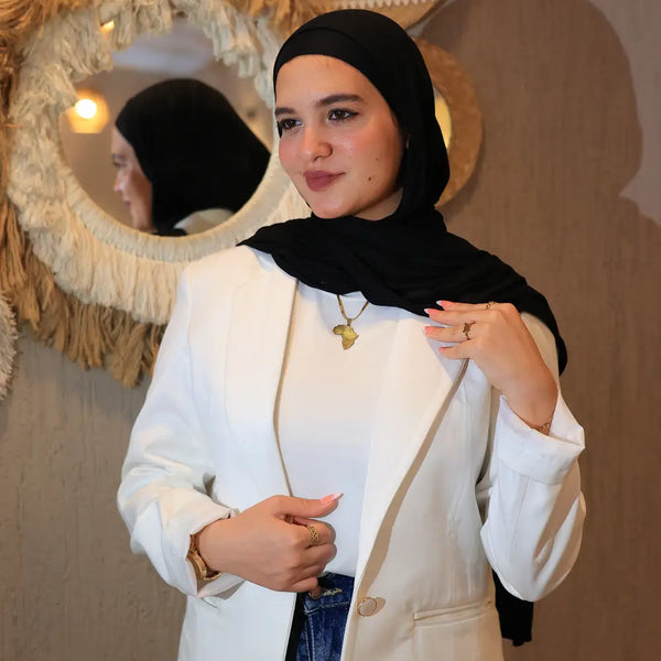 “ZAYTA off white women’s blazer on model wearing black hijab, tailored fit, in front of decorative wall mirrors”