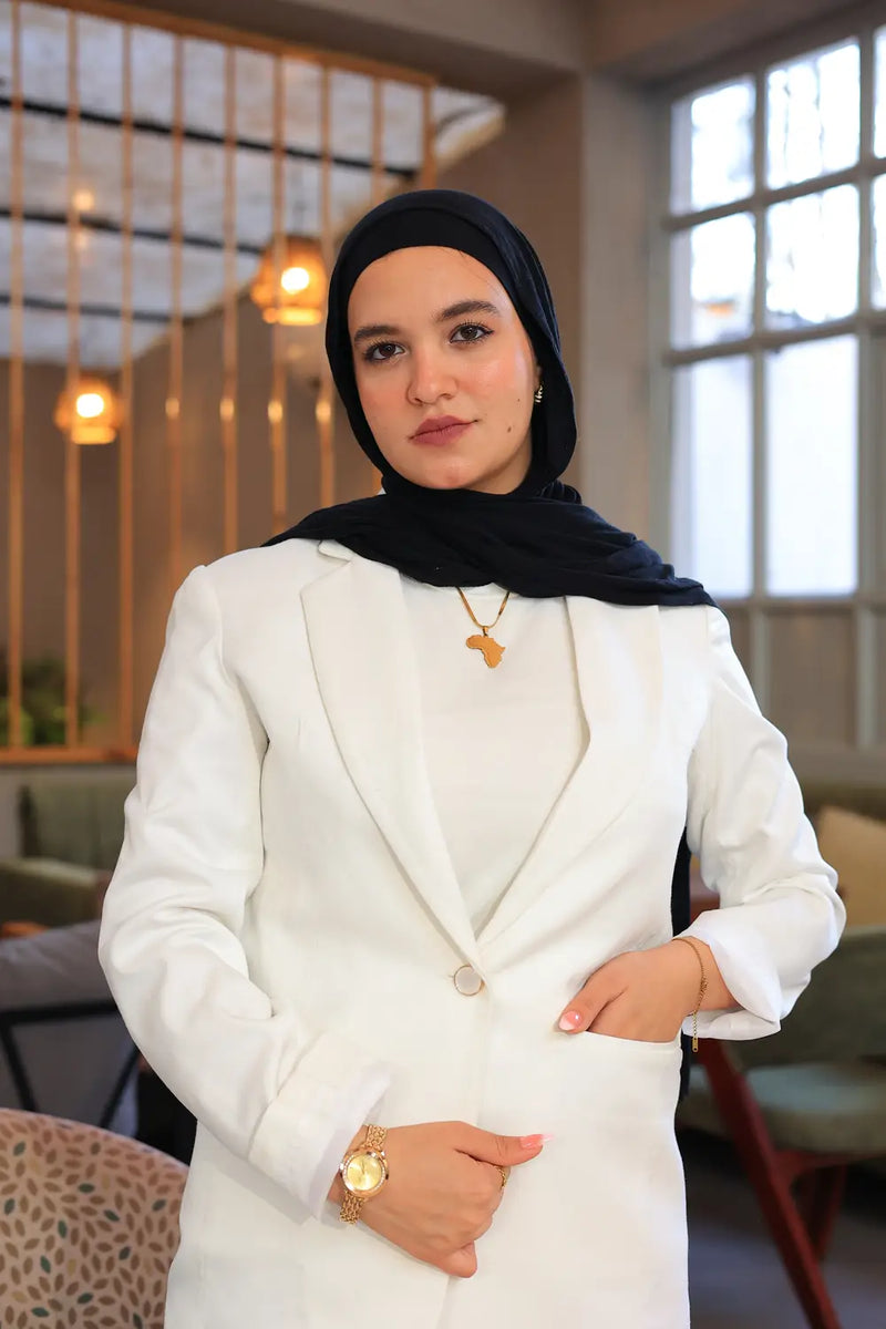 “ZAYTA off white tailored blazer on model wearing black hijab, close-up of fabric and lining, indoor setting”