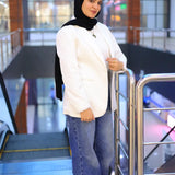 “ZAYTA off white women’s blazer on model paired with white sweater and blue jeans, modern indoor setting with escalators”
