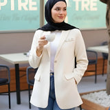ZAYTA Of-White tailored blazer on model wearing black hijab, showing fabric and inner lining, holding a phone in casual setting