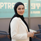 ZAYTA off-white tailored blazer on model wearing black hijab, showing fabric and inner lining, standing outdoors with blurred background
