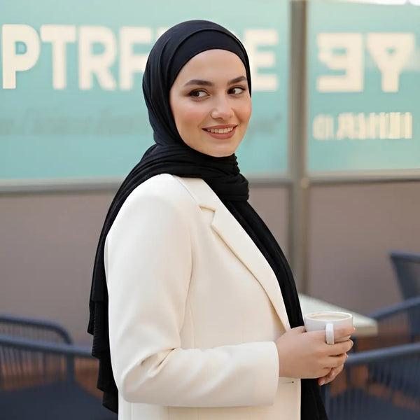 ZAYTA off-white tailored blazer on model wearing black hijab, showing fabric and inner lining, standing outdoors with blurred background